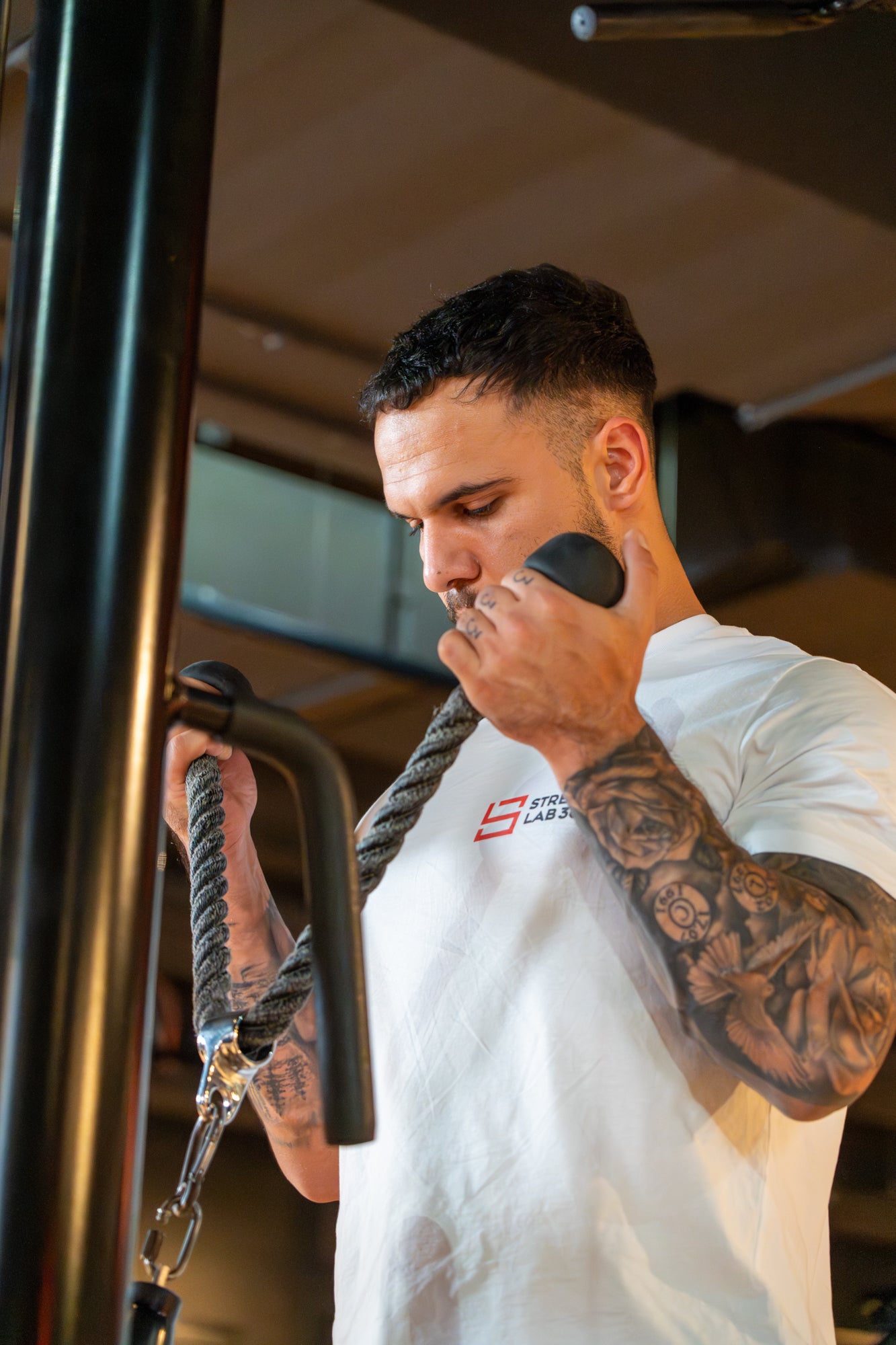 An athlete performing a cable biceps curl with a rope attachment, emphasizing controlled movement and targeted bicep activation, following StrengthLab360’s precision training principles.